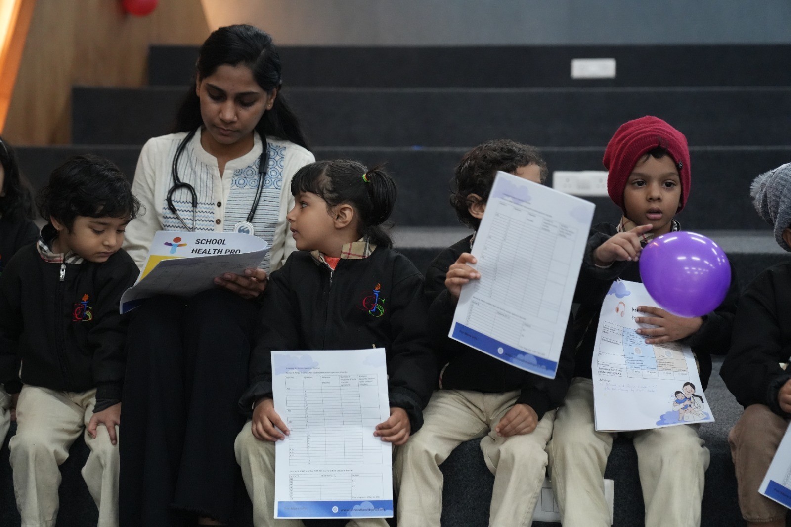 Doctor reviewing health-screening reports with students